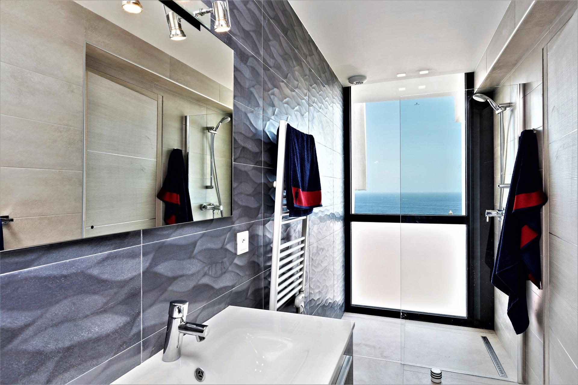 A BATHROOM WITH WALKING SHOWER IN VILLA INFINITY