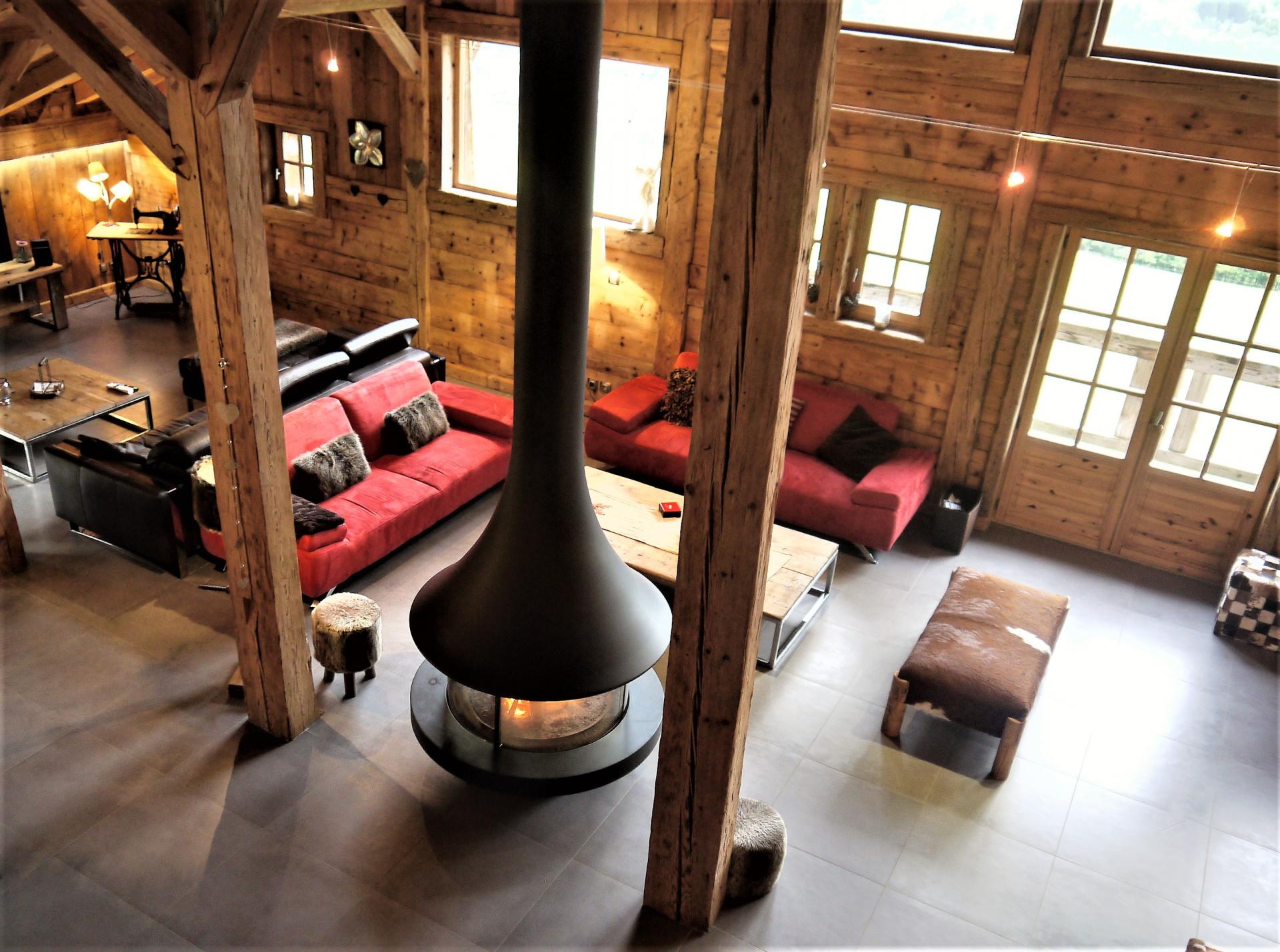 AN OPENED LARGE LIVING ROOM WITH ITS FIREPLACE IN CHALET DE LA FERME IN THE ALPS